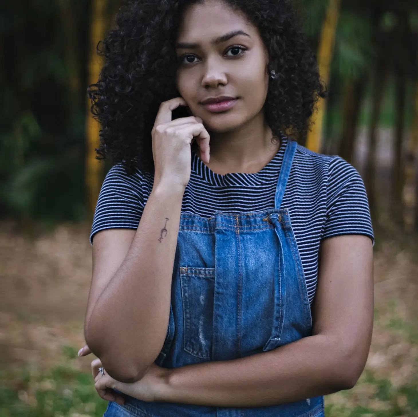 Portrait d'une jeune femme avec des arbres derrière.